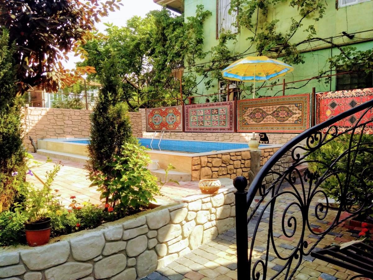 The garden pool with Georgian carpets on the stone wall